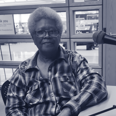 Black woman sits at microphone