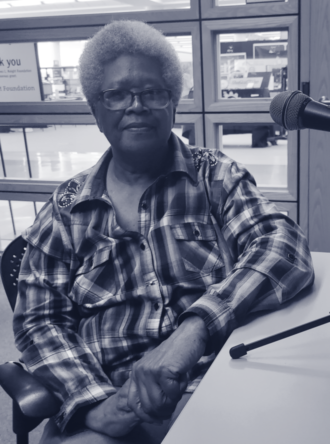 Black woman sits at microphone